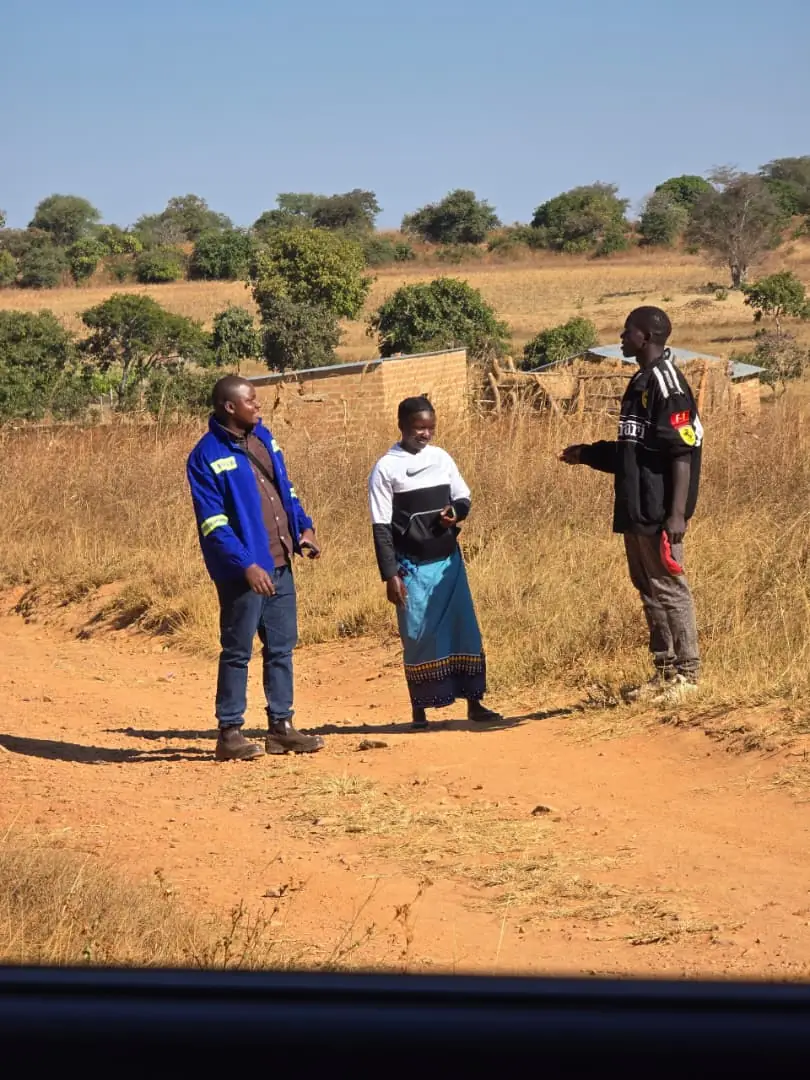 A SunWise team member speaking with residents beside a rural track during environmental fieldwork