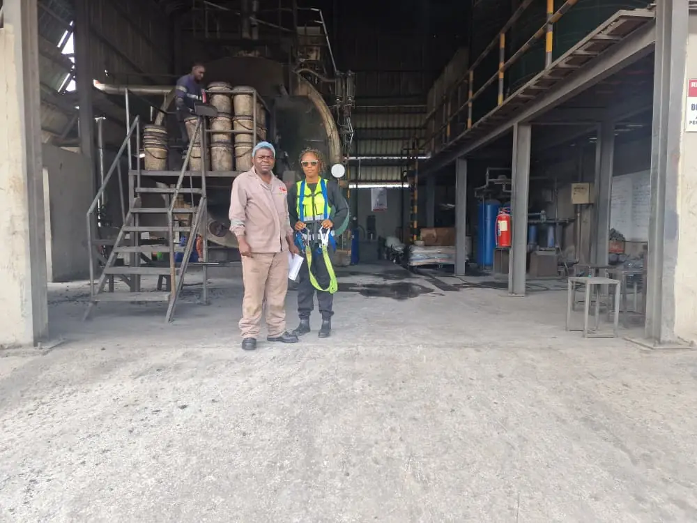 Site personnel wearing protective coveralls, helmets, high-visibility vests and a full-body fall-arrest harness