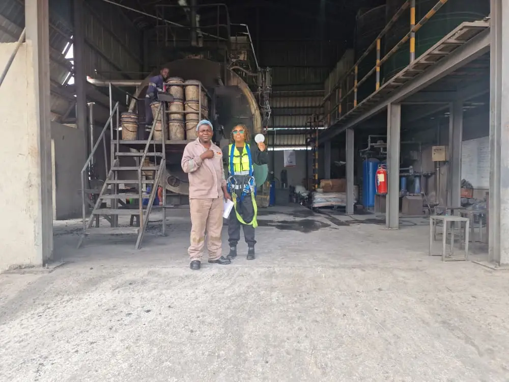 SunWise personnel in protective coveralls and helmets standing inside a working industrial plant