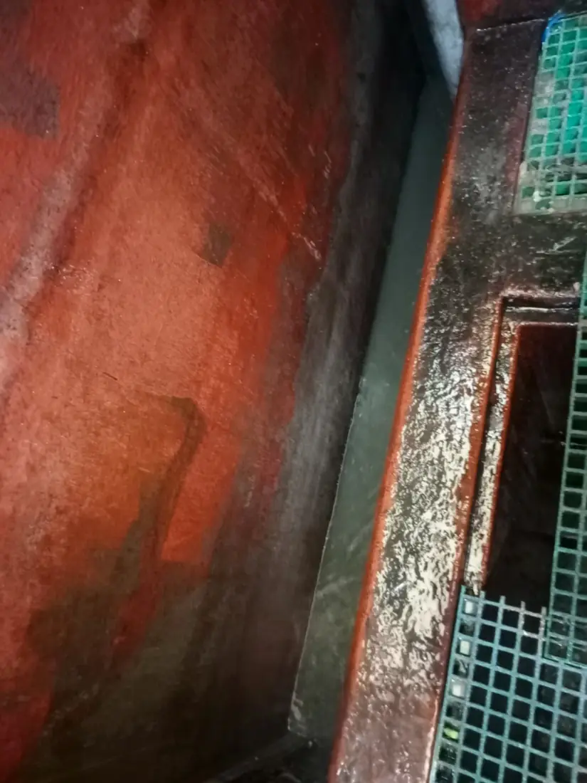 Cleaned internal wall of a steel chamber beside an open side channel and floor grating