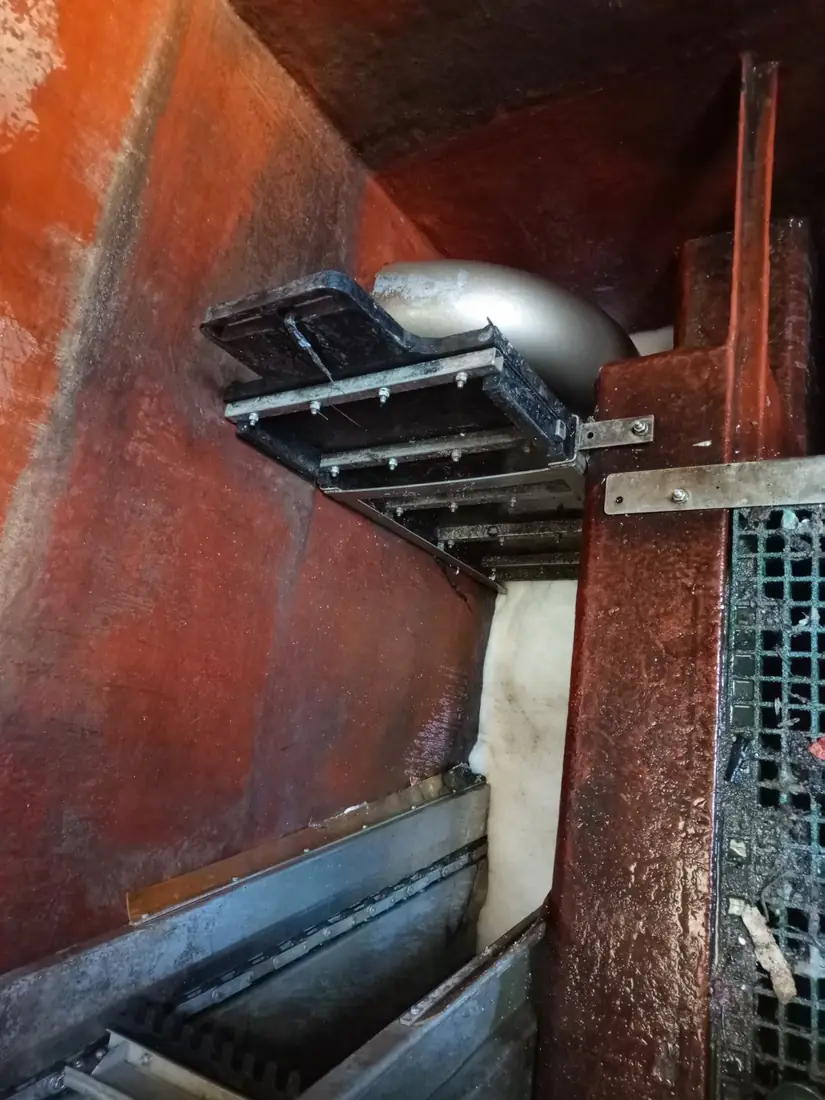 Stainless steel inlet pipe elbow and support steelwork inside a cleaned steel storage chamber